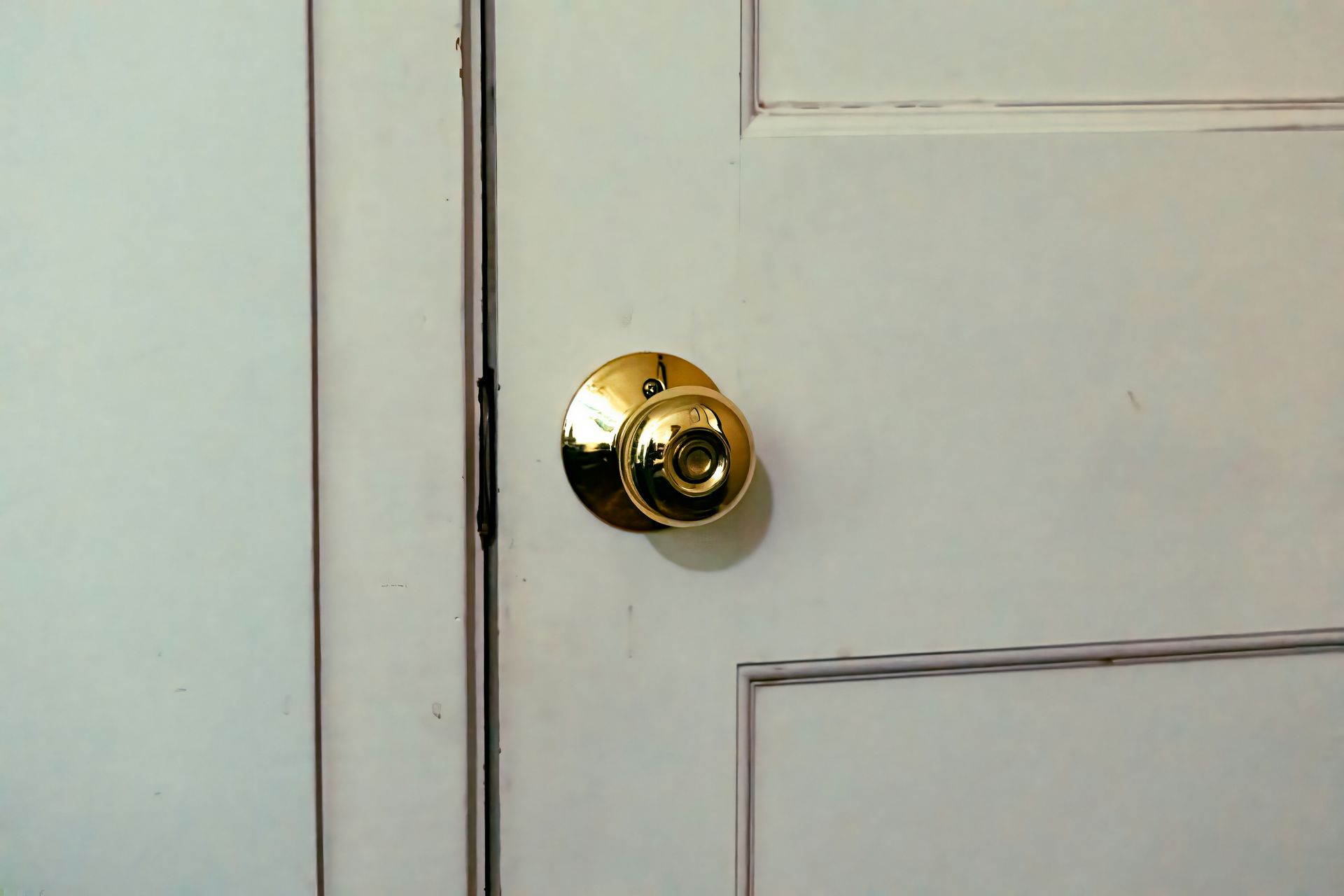 A close up of a door handle on a white door